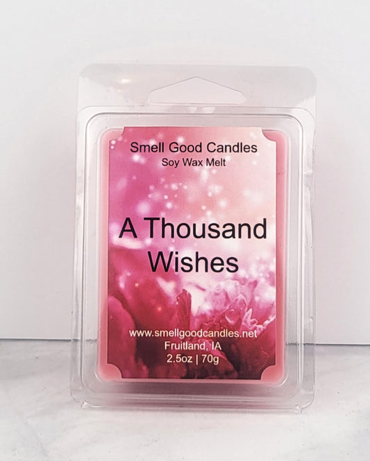 Pink wax melt inspired by BBW fragrance next to jasmine flowers and peony petals