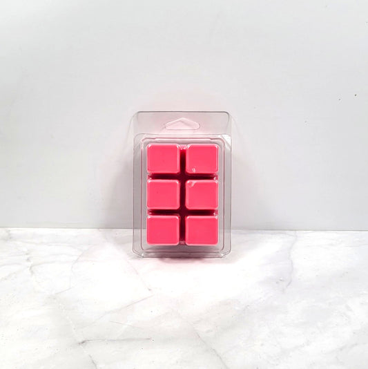 Pack of pink wax cubes in clear packaging on a white surface